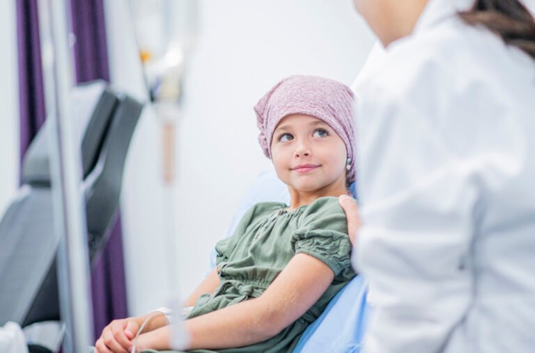 A little girl shares a smile with her female Doctor at her bedside